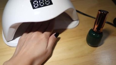 Oje sürüyorum ve kurutmak için ultraviyole lamba kullanıyorum..