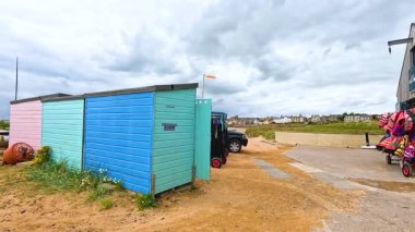 Kıyıya yakın renkli barakalar ve tekneler.