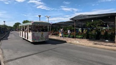 Yolcular dışarıda tren yolculuğunun keyfini çıkarıyorlar.