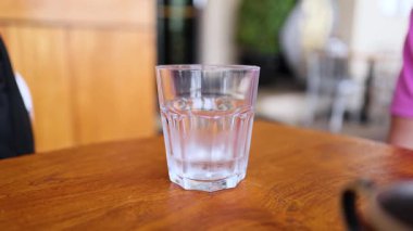 Masadaki bardağa su dökülüyor.