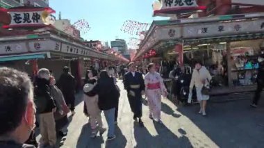 Çeşitli ziyaretçi ve dükkanlarla kalabalık bir açık hava pazarı.