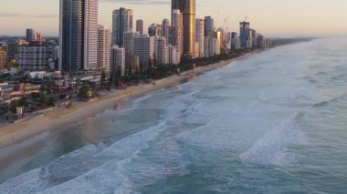 Hava görüntüleri, gün doğumunda Gold Coast 'un kıyı şeridi ufuk çizgisini, dalgaları, kumlu sahilleri ve yüksek binaları yakalar.