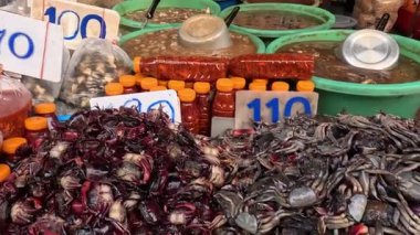 Yengeçler kalabalık bir pazarda satılıyor.