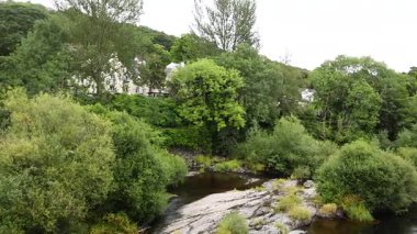 Nehir yemyeşil ve binalardan akıyor.
