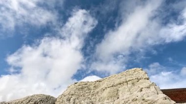 Parçalı bulutlu gökyüzünün altında beyaz uçurumlar