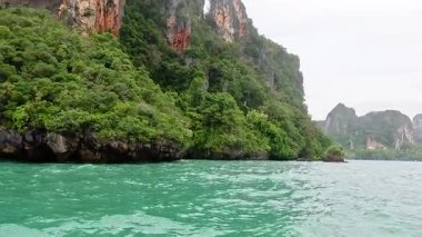 Tayland, Krabi yakınlarındaki yemyeşil kayalıklar ve turkuaz sular.