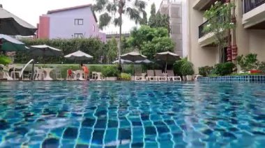 Sakin bir otel havuzuna yağmur yağıyor.
