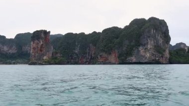 Uzun kuyruklu tekne Krabi 'nin kayalık adalarını geçiyor.