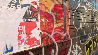 Duvar yazısıyla kaplanmış posterler ve etiketlerle