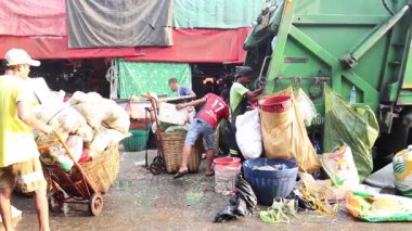 İşçiler işbirliği içinde atık ayıklıyor ve topluyorlar.