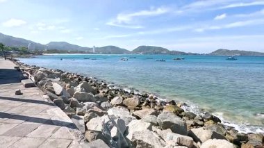 Açık mavi suları ve kayalık kıyı şeridi olan sakin bir sahil manzarası Kalim Sahili, Phuket 'te.