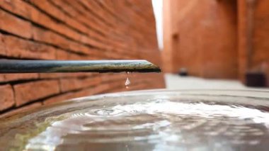 Bir damla su bir musluktan iner.