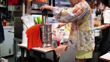 Yerel bir markette taze meyve suyu hazırlıyorum.