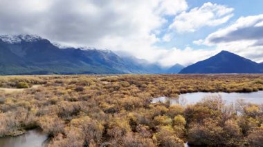 Havadan çekilen görüntüler Glenorchy 'nin geniş ve renkli manzarasını dağlar, bulutlar ve dinamik ışık altında yansıtıcı suyla yakalıyor.