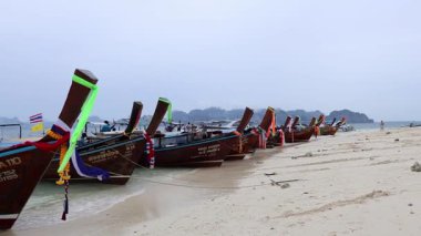 Renkli tekneler sakin bir Tayland sahiline yanaştı.