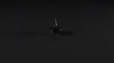 Karanlık bir yüzeyde dönen dönen bir üst