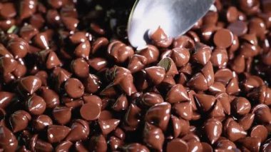 Kaşık yığından çikolata parçaları topluyor.