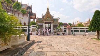 Ziyaretçiler Bangkok 'taki süslü Wat Phra Kaew Tapınağı' nı keşfederek, güneşli gökyüzünün altındaki karmaşık mimarisini ve canlı atmosferini yakaladılar.