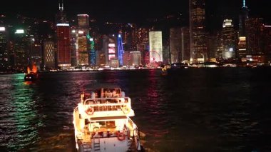 Illuminated boat cruising through Hong Kong's harbor