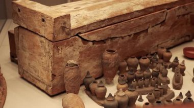 Tahta tabut tarihi çömlek eserleriyle çevrili.