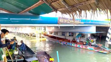 Yüzen bir pazarda canlı tekneler ve satıcılar