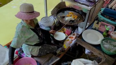 Tedarikçi yüzen pazarda Pad Thai hazırlıyor.