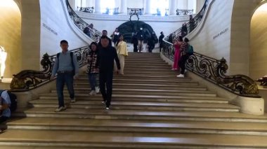 Müzedeki süslü merdivenlerde yürüyen turistler