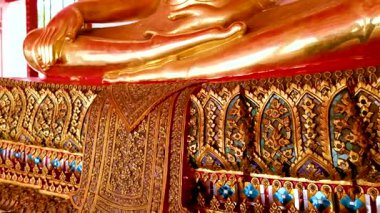 Altın Buda heykelleri Wat Pho, Bangkok 'ta zengin dekore edilmiş bir koridorda. Parlak ışıklandırma karmaşık ayrıntıları ve sakin atmosferi vurguluyor