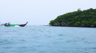Tayland sularındaki Krabi adasında uzun kuyruk teknesi