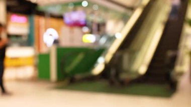 İnsanlar alışveriş merkezinde yürüyen merdiven kullanıyor.