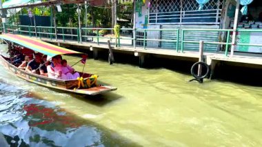Canlı, uzun kuyruklu bir tekne turistleri Bangkok 'ta hareketli bir kanal boyunca taşıyarak yerel kültürü ve canlı su yolu manzaralarını gözler önüne seriyor.