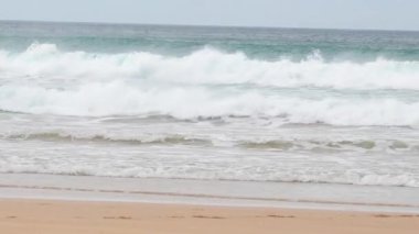 Dinamik okyanus dalgaları Avustralya 'daki Büyük Okyanus Yolu' nun kumlu sahillerine çarpar. Yumuşak doğal ışık altında sakin sahil güzelliğini yakalar.