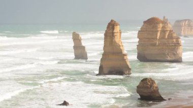 Muhteşem kireçtaşı yığınları, yumuşak gün ışığında okyanustan yükseliyor ve Avustralya Büyük Okyanus Yolu boyunca doğal güzellikleri sergiliyor.