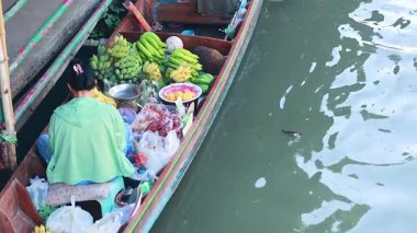 Satıcı bir kanal teknesinde ürün satıyor.
