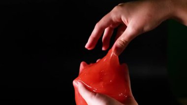 Eller, esnek kırmızı balçığı yönlendiriyor.