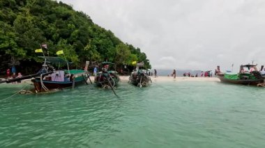 Tropik bir plajda tekneler ve turistler