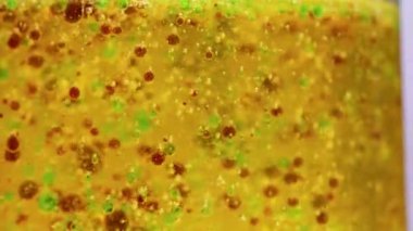 Bir deney tüpündeki renkli damlacıklarla canlı kimyasal reaksiyon, laboratuvar ortamında yoğunluk ve ayrışma gösteriyor