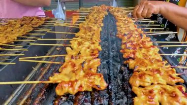 Biftekler sokak satıcıları tarafından ızgara ediliyor.