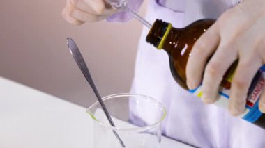 Reaksiyon için bir deney şişesinde kimyasallar karıştırılıyor.