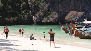 İnsanlar tropikal plajda güneşli bir günün tadını çıkarıyorlar.