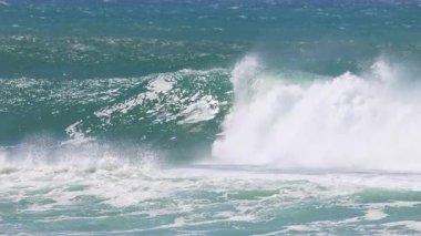 Sörfçü Kirra Sahili 'nde dalgalara biniyor.