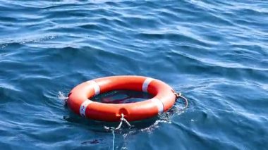 Tayland, Phuket 'te okyanus yüzeyinde bir can simidi sürükleniyor. Hafif su hareketiyle gün ışığında yakalanır.