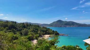 Tayland, Phuket 'teki Laem Singh Sahili' ndeki yemyeşil ve turkuaz suların açık mavi gökyüzü altında havadan görünüşü