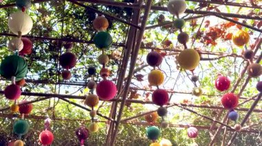 Çiçekli bir bahçede sallanan enerjik fenerler.