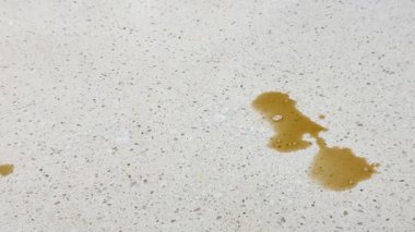 Bir el, kağıt havlu kullanarak aydınlık bir tezgaha kahve döker ve etkili temizlik tekniğini gösterir.