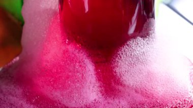 Kuru buzla canlı bir bilim deneyi cam bir kabın içinde renkli kabarcıklar yaratıyor, kimyasal reaksiyonlar ve canlı görüntüler sergiliyor.