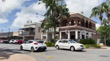 Tarihi bir bar binasının önünden arabalar geçiyor.