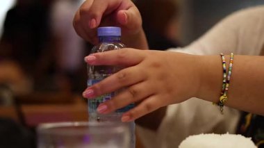 Halka açık bir ortamda eller şişe açıyor.