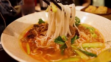 Yemek çubuklarıyla kaseden erişteler çalındı.