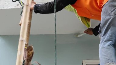 Tavan boyayan bir işçinin sıralı çerçeveleri